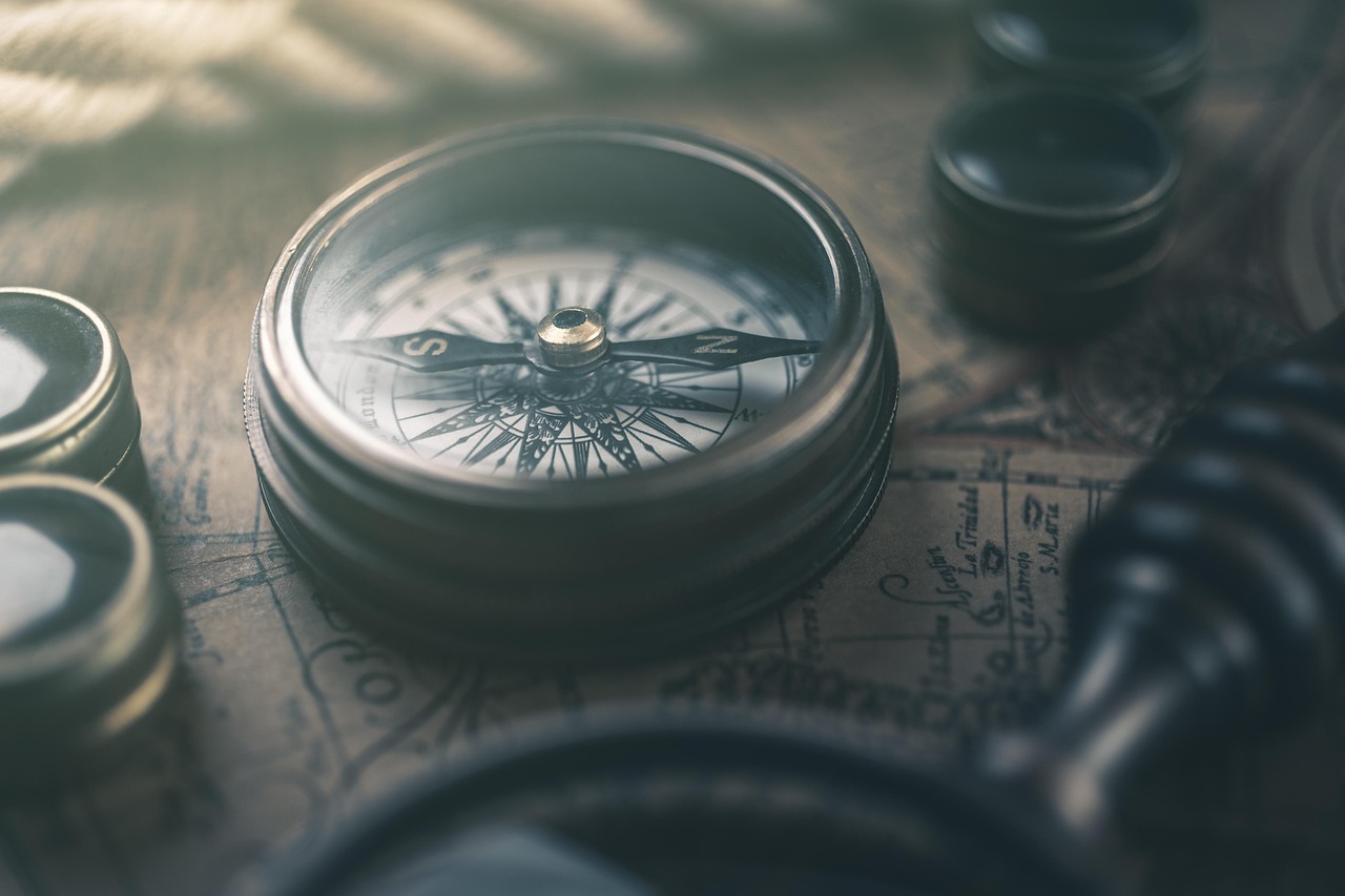 Compass and folded map arranged on a desk